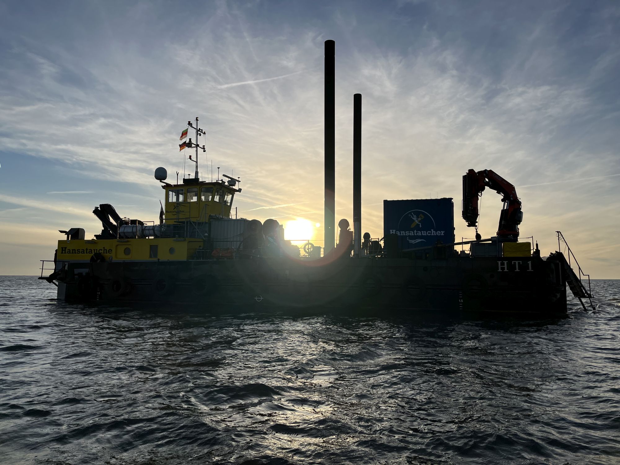 Silhouette eines Schiffs vor niedrigstehender Sonne