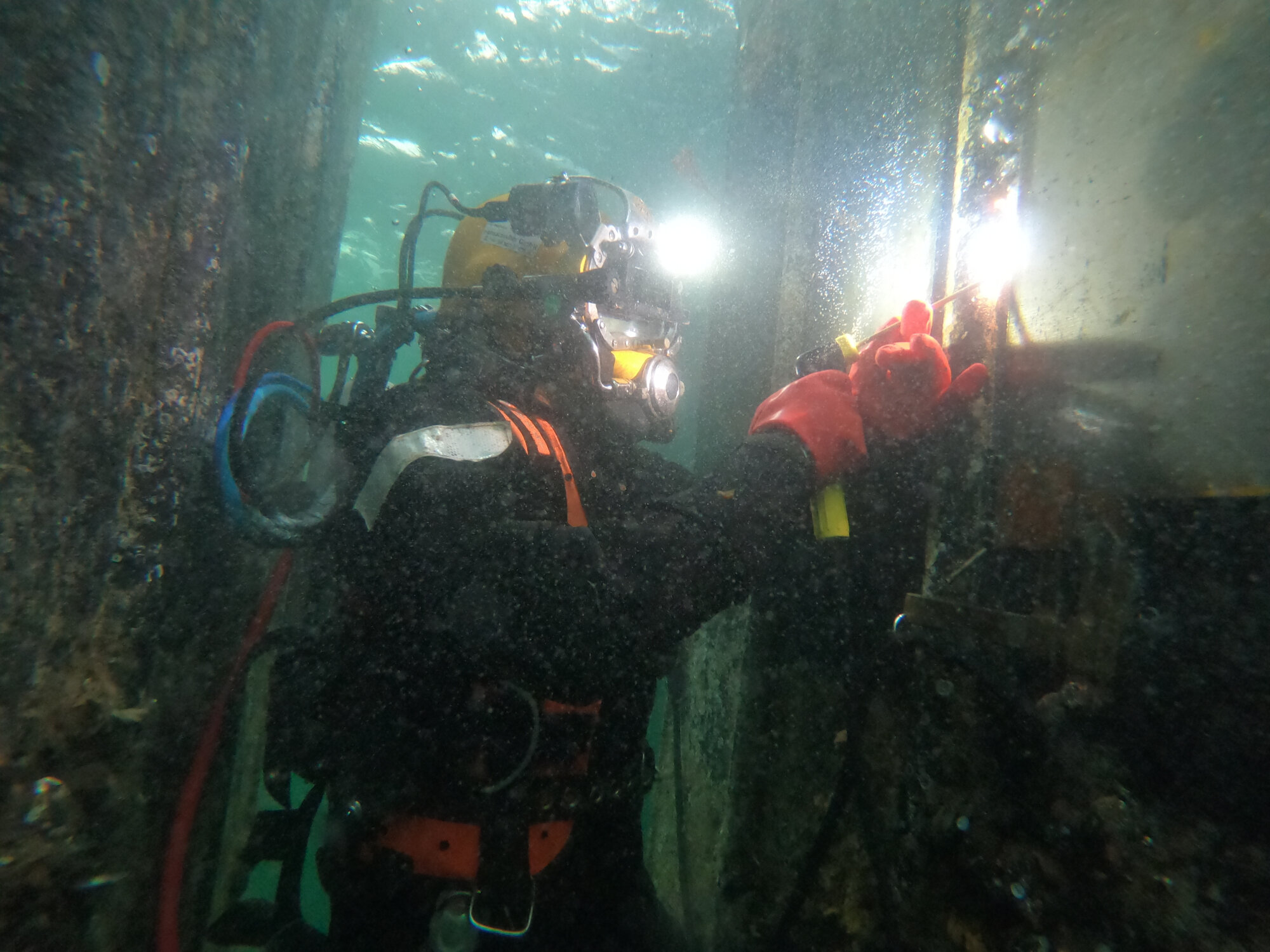 Ein Taucher führt unter Wasser Schweißarbeiten durch.