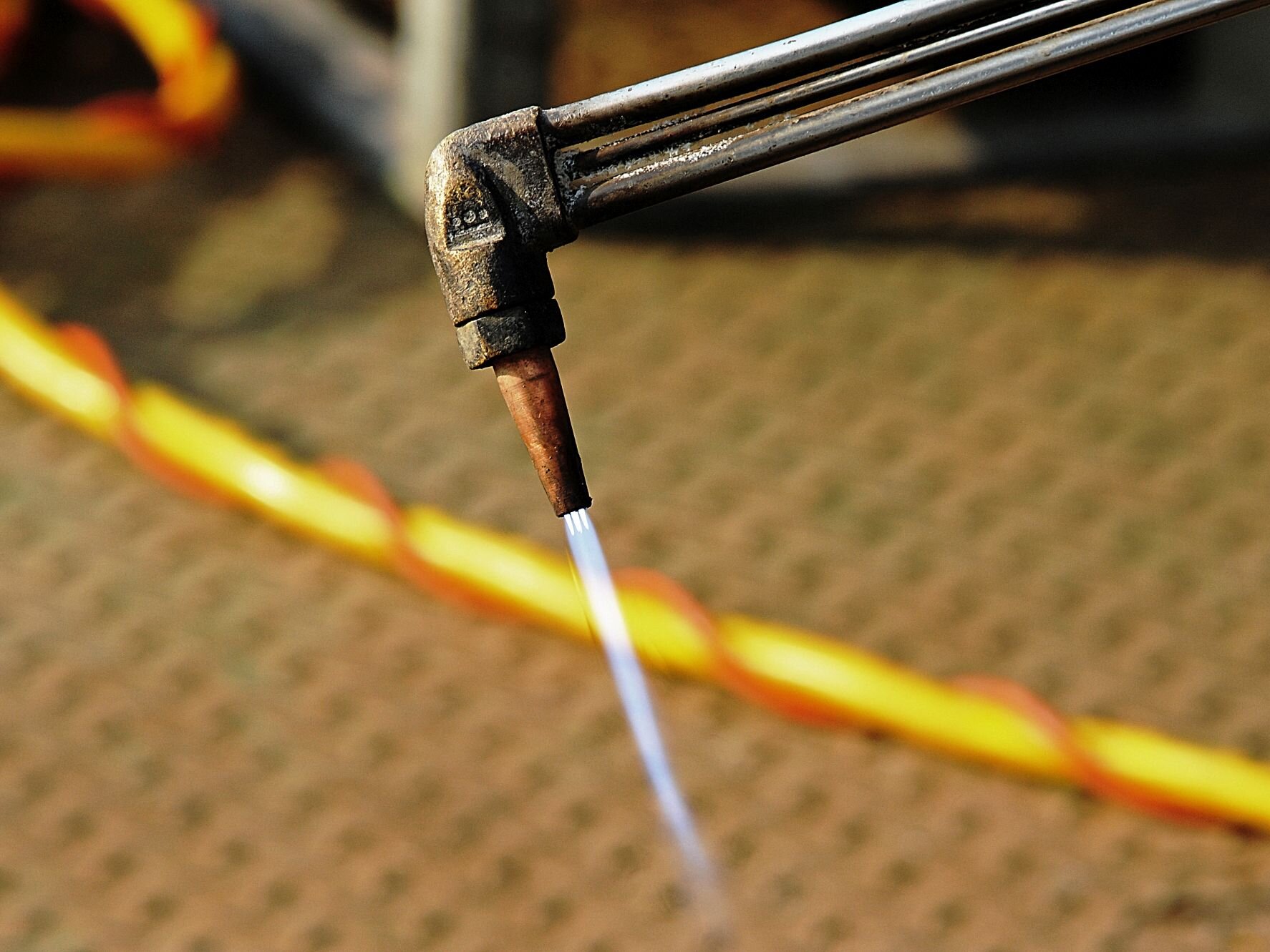 Welding beam over steel floor, a yellow cable in the background